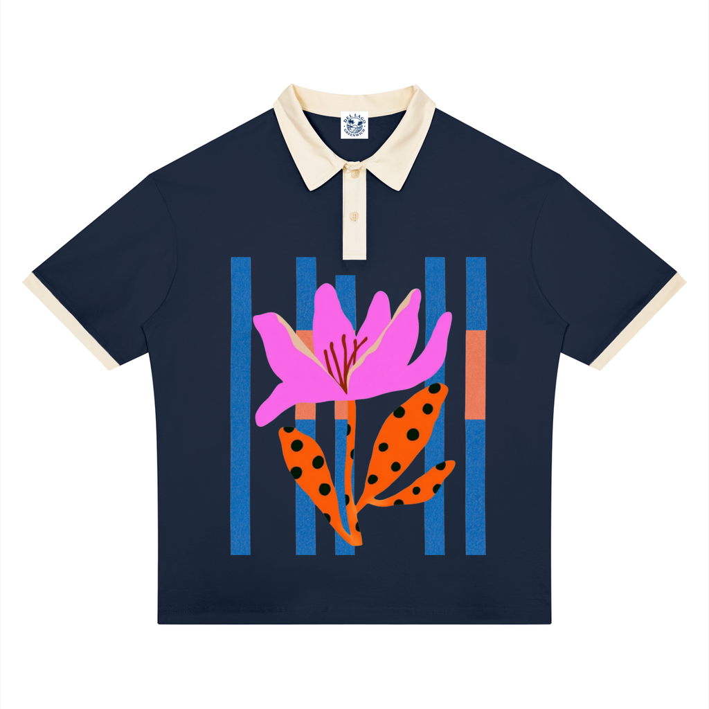 A navy blue short-sleeve polo shirt with a cream collar and sleeve cuffs, featuring a colorful graphic print of a pink flower and orange spotted leaves against blue and orange vertical stripes on the front.