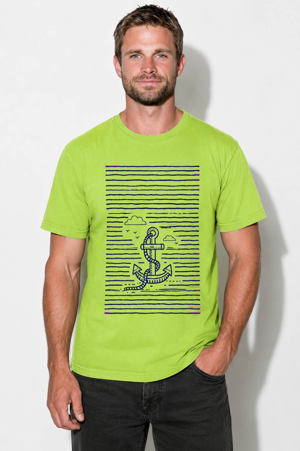 A man wearing a bright lime green t-shirt with a navy blue horizontal stripe graphic and an astronaut anchor design on the front, paired with black jeans, standing against a light gray wall.