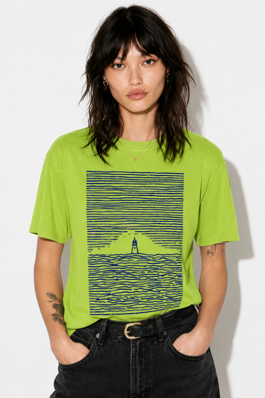 A model wearing a bright lime green graphic t-shirt with a blue striped lighthouse design, paired with black jeans, against a plain white background.