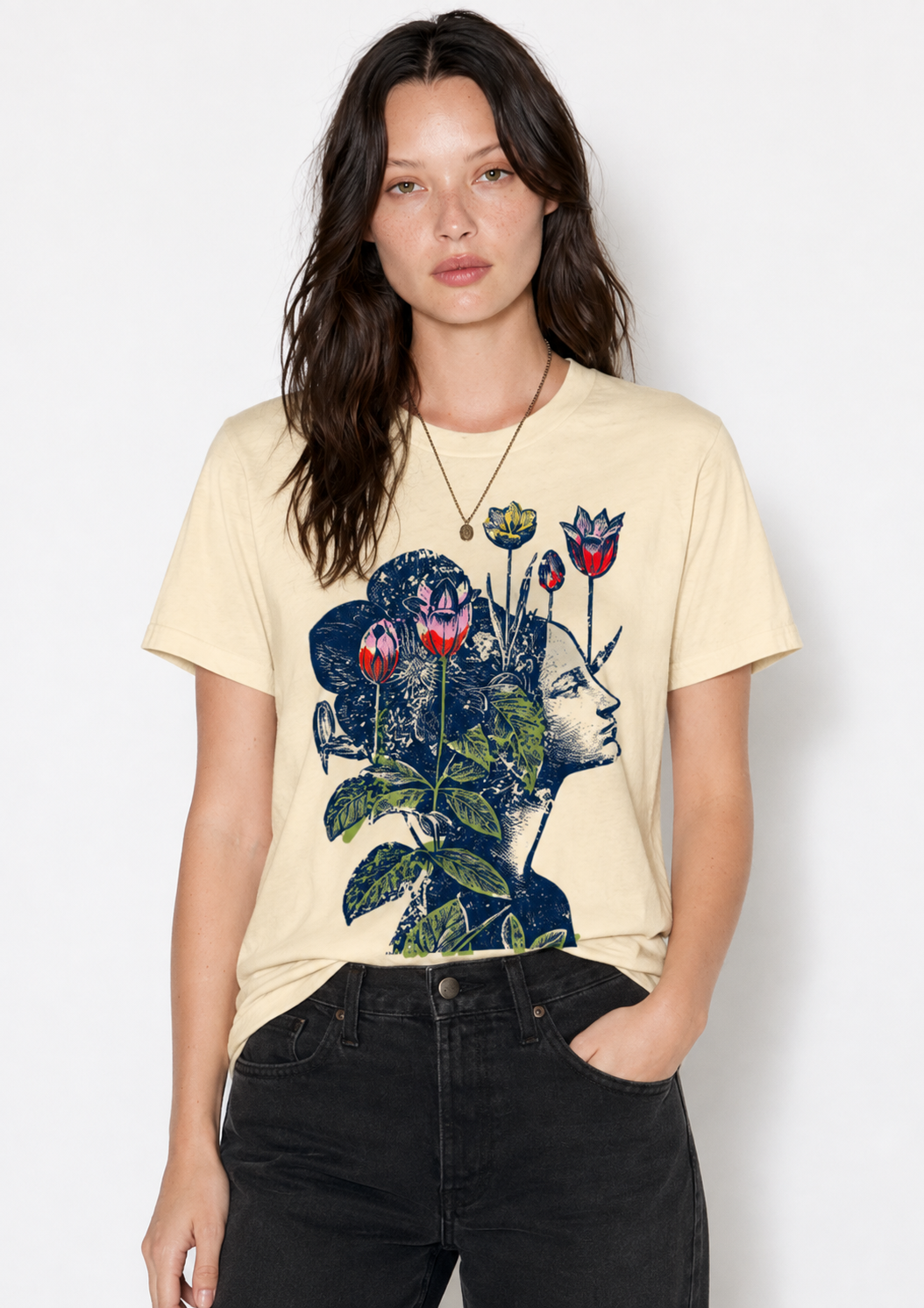 A woman modeling a cream-colored graphic t-shirt with a dark blue and red floral illustration on the front, paired with black jeans, against a plain light gray background.