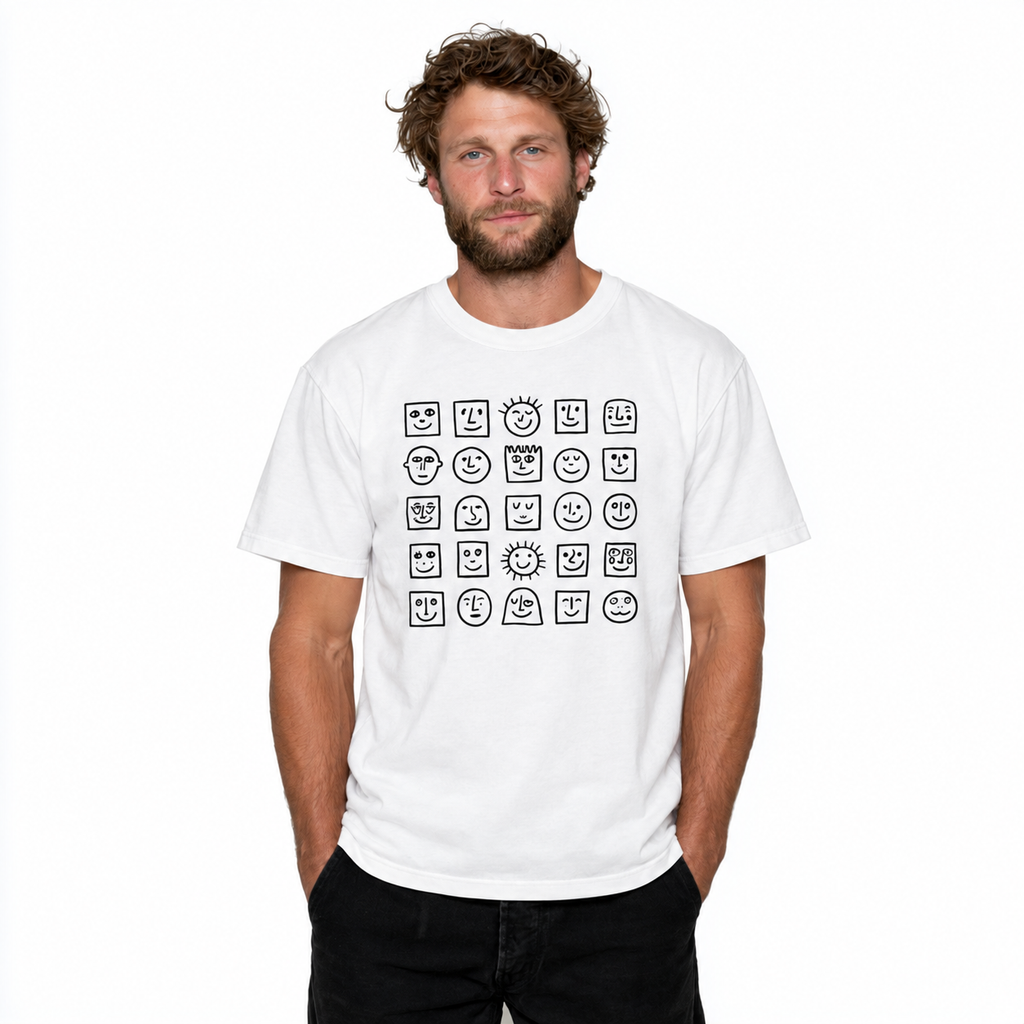 A man wearing a white short-sleeve t-shirt with a black graphic of 21 different cartoon faces arranged in a grid on the chest, set against a plain white background.