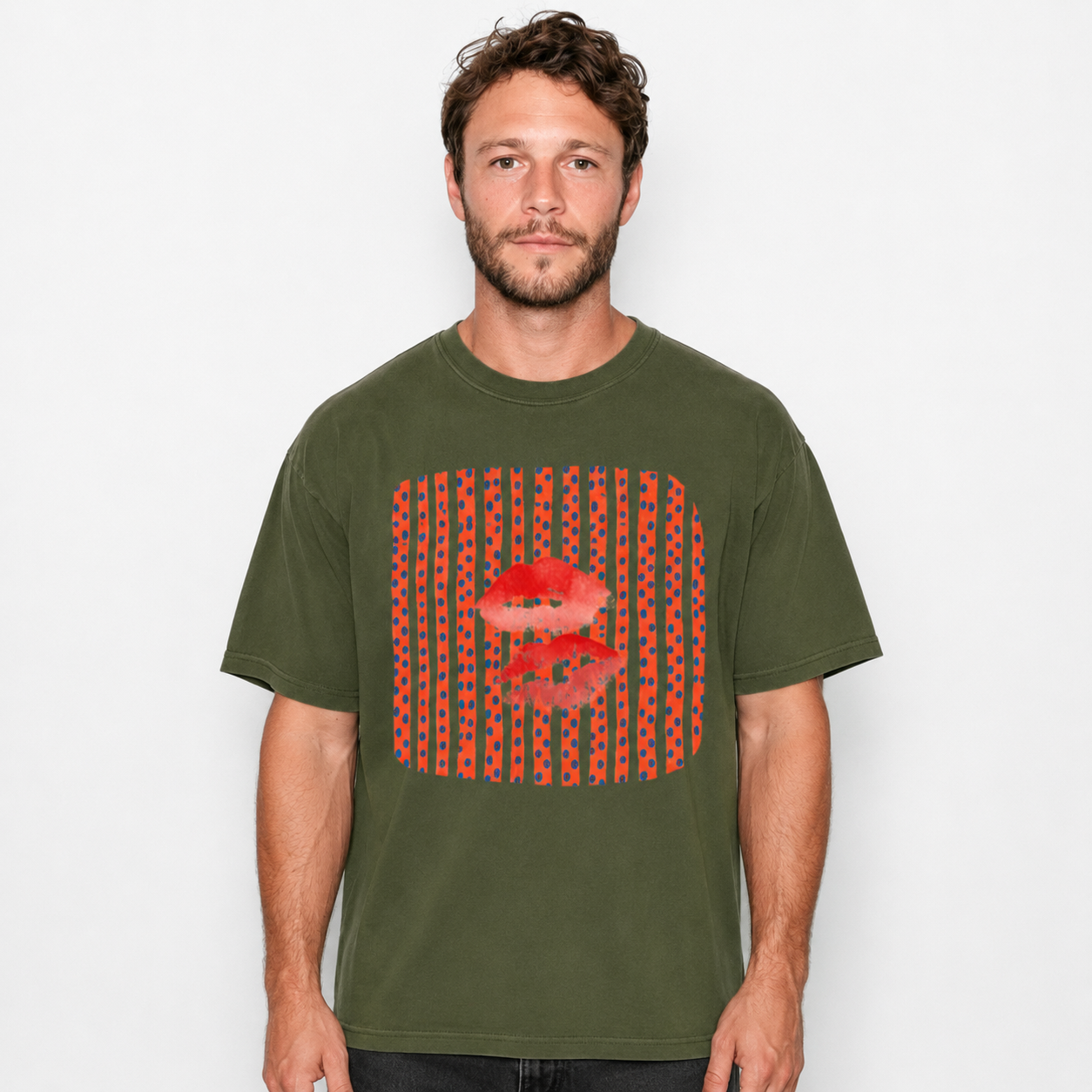 A man wearing an olive green t-shirt with a red graphic print of lips and vertical stripes, photographed against a light gray background.