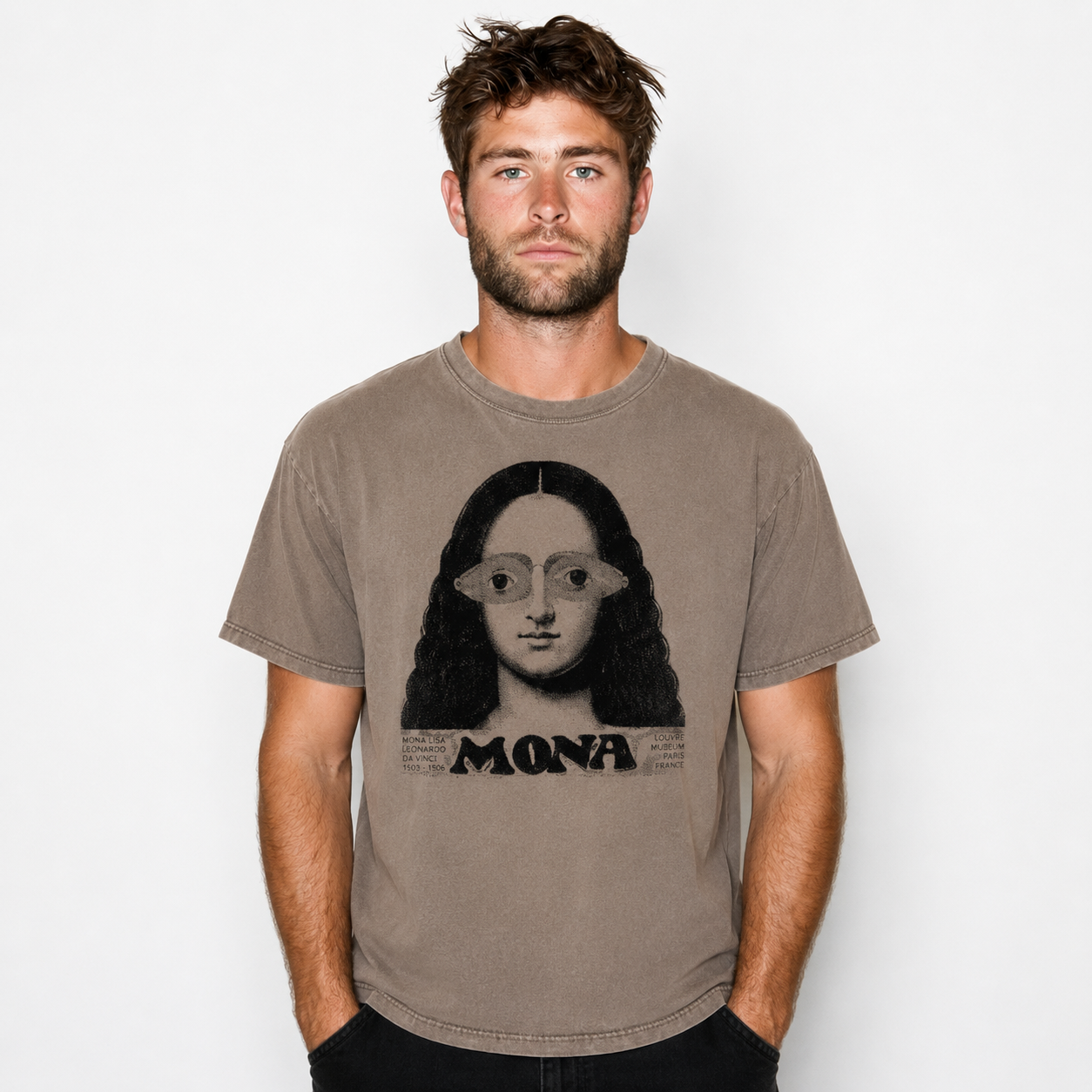 A man wearing a faded brown graphic t-shirt featuring a stylized portrait of Mona Lisa with the word 'MONA' printed below, set against a plain light gray background.