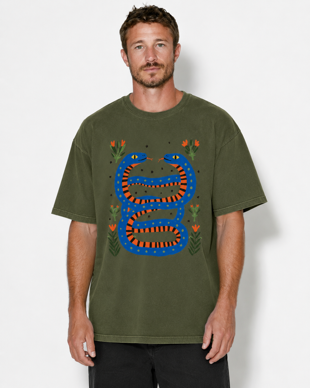 A man wearing an olive green t-shirt with a colorful graphic of a blue and orange snake wrapped around a tree trunk, surrounded by small orange flowers, against a light gray background.