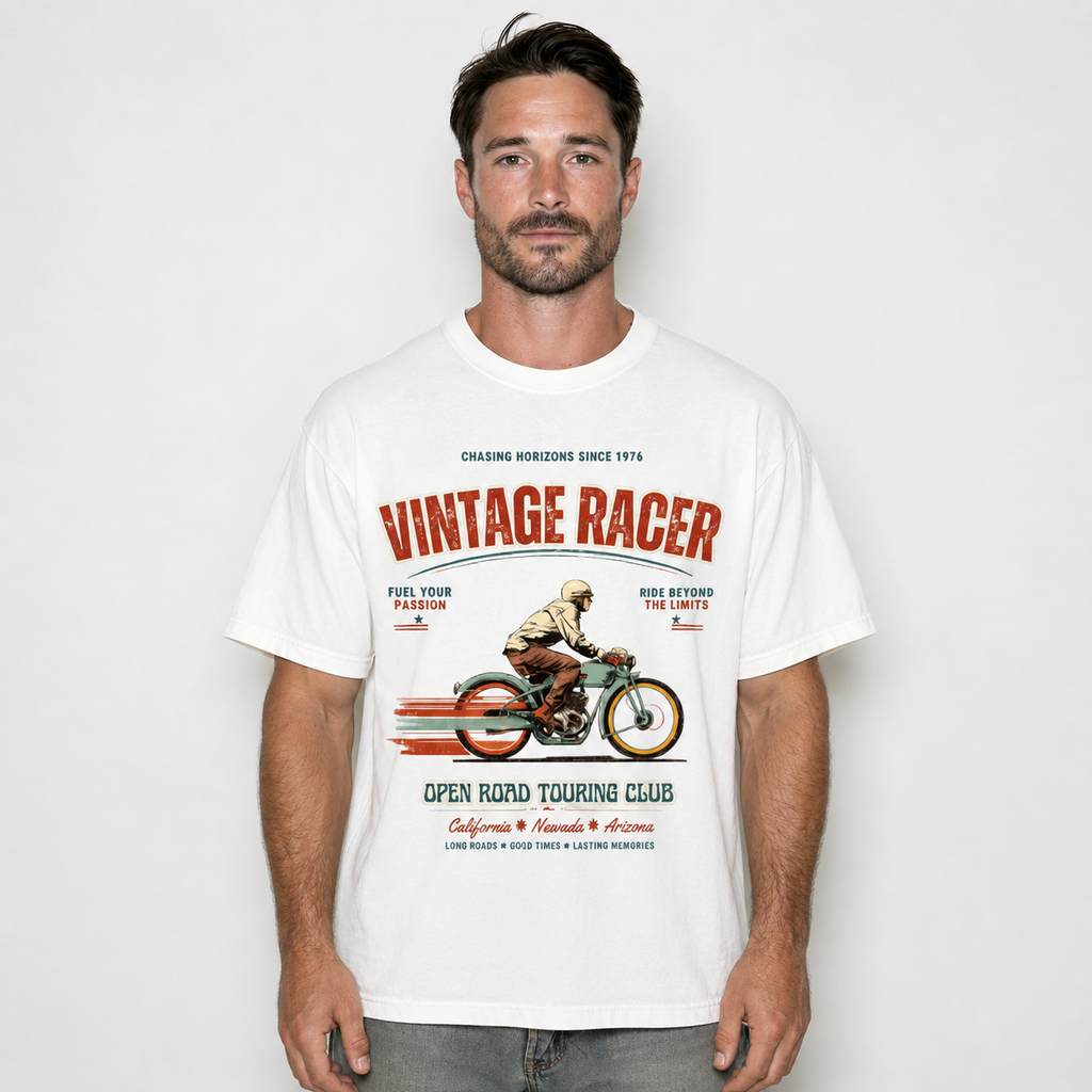 A man wearing a white graphic t-shirt with a vintage road racing design. The graphic features the text 'VINTAGE RACER' in red and black, along with an illustration of a motorcycle racer and the text 'OPEN ROAD TOURING CLUB'.