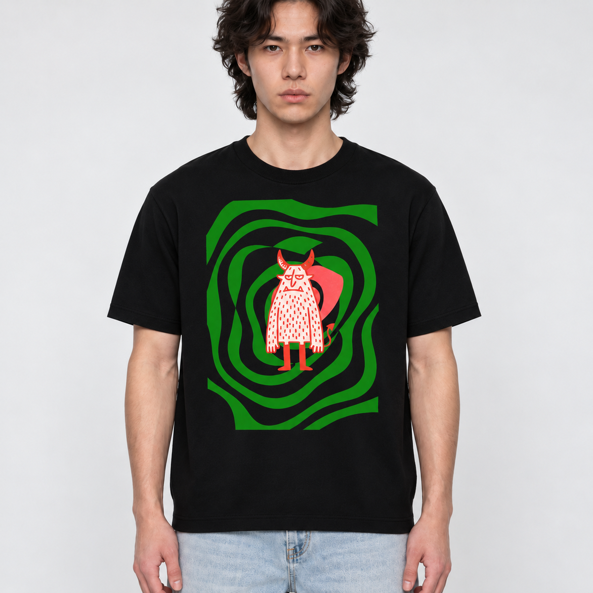 Model wearing black Devil’s Garden graphic tee with green swirl and red horned character design