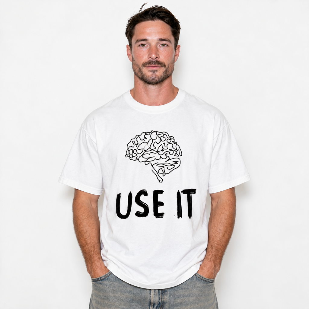 A man wearing a white crewneck t-shirt with a black line art graphic of a brain and the text 'USE IT' printed on the front, paired with gray jeans, against a plain white background.
