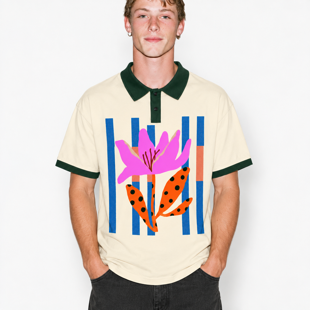 A man wearing a cream-colored short-sleeve polo shirt with a dark green collar and sleeve cuffs, featuring a colorful graphic print of a pink flower and orange leaves against blue and orange vertical stripes.