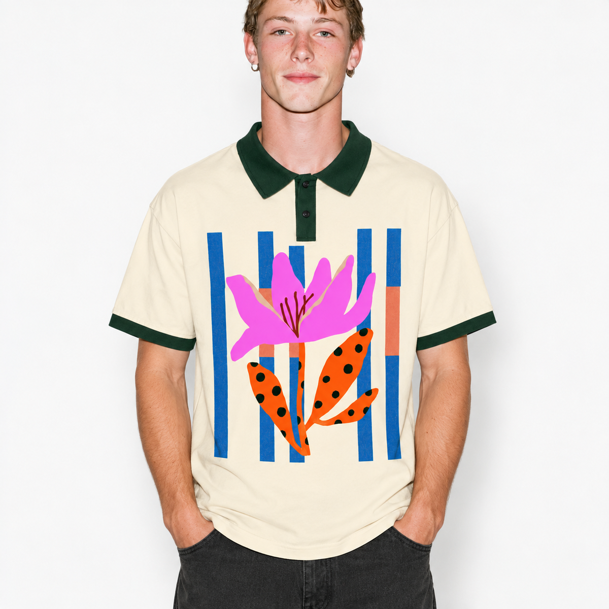 A man wearing a cream-colored short-sleeve polo shirt with a dark green collar and sleeve cuffs, featuring a colorful graphic print of a pink flower and orange leaves against blue and orange vertical stripes.