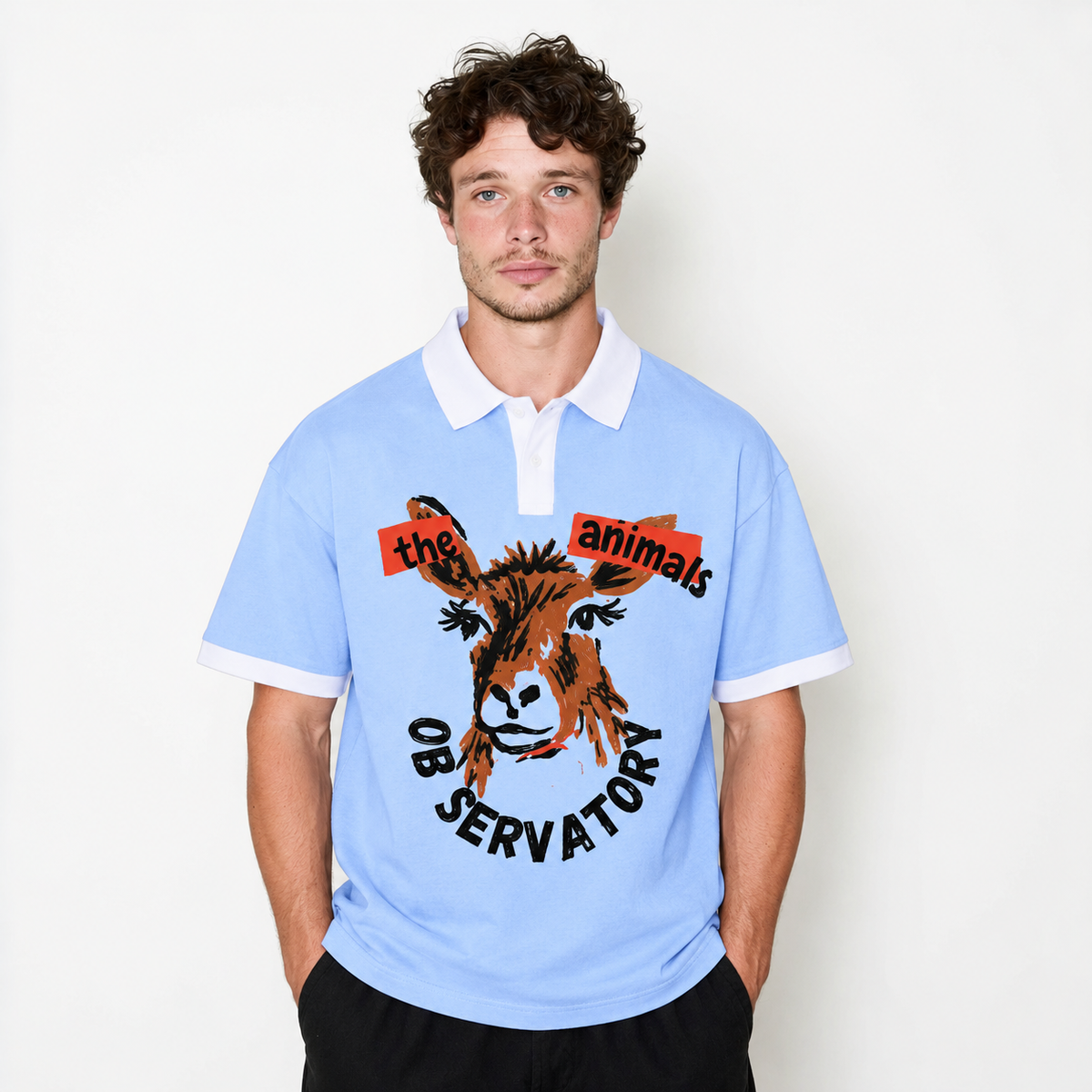 A man wearing a light blue short-sleeve polo shirt with a white collar and sleeve cuffs, featuring a graphic of a donkey with red and black text reading 'the animals observatory'.