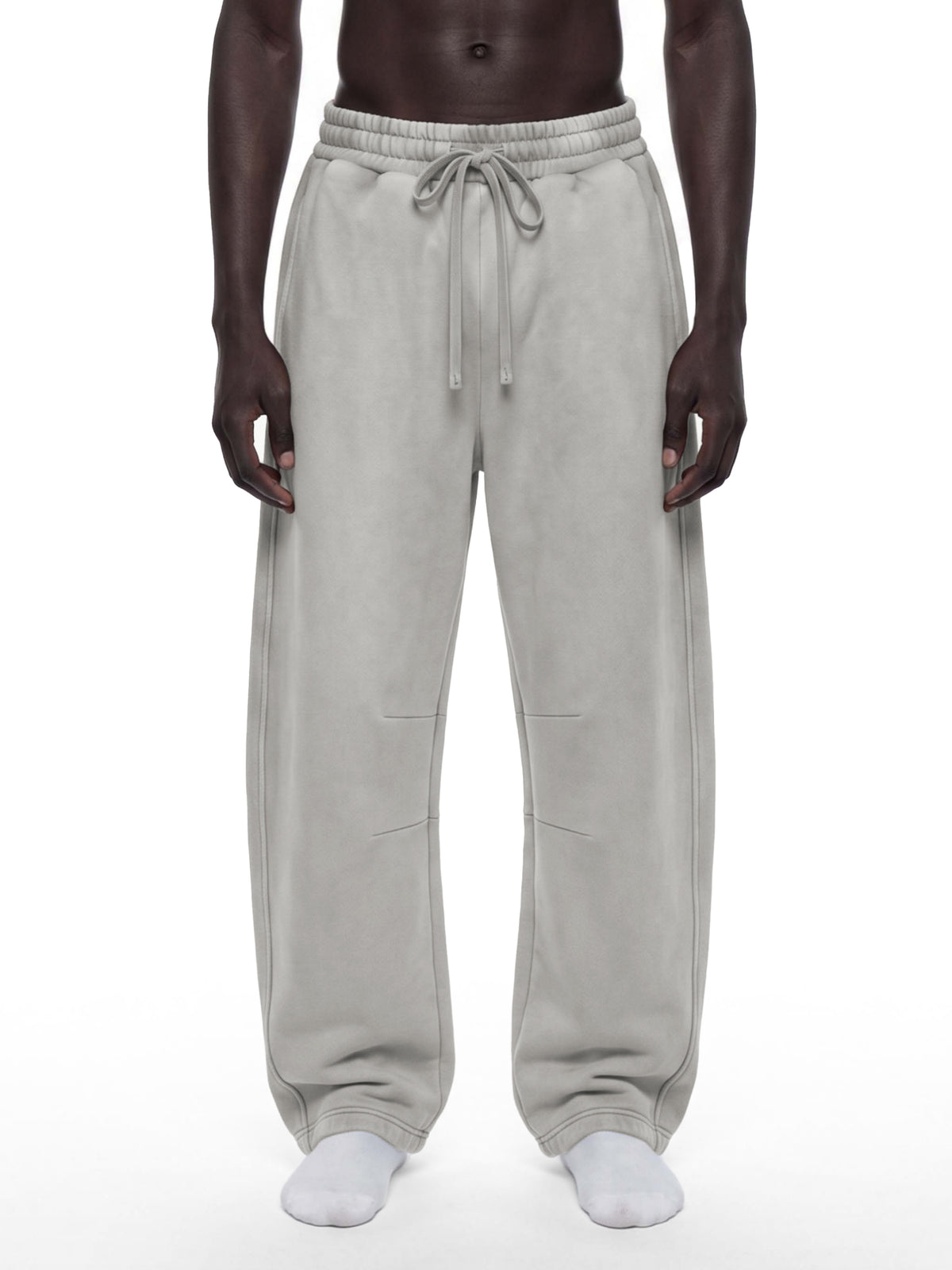 A model wearing light gray drawstring sweatpants, shown from the waist down against a plain white background.